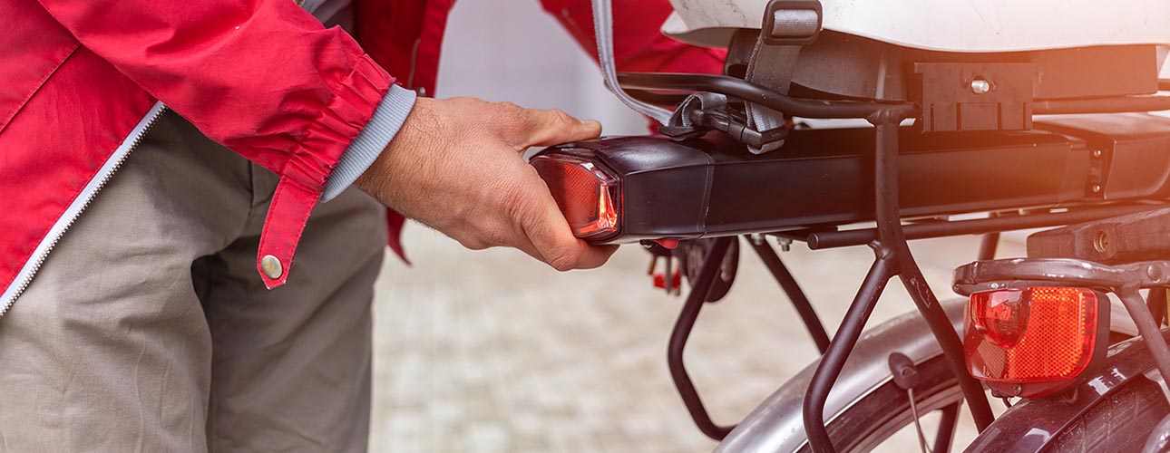 Een gebruiker van een elektrische fiets haalt de batterij uit zijn fiets