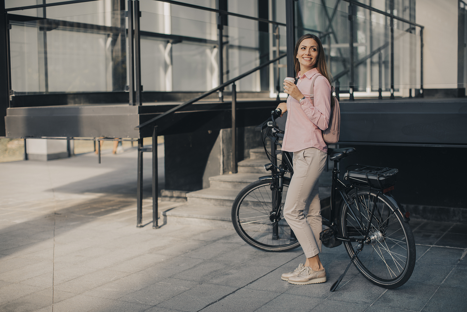 Jonge vrouw naast elektrische fiets
