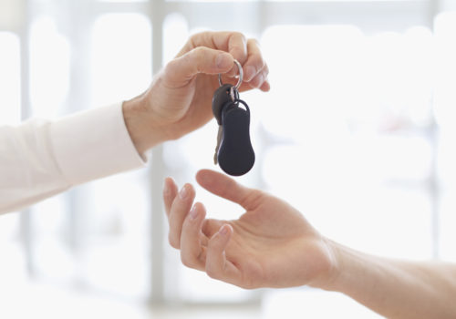 Main tendant une clé lors de l'achat d'une voiture d'occasion