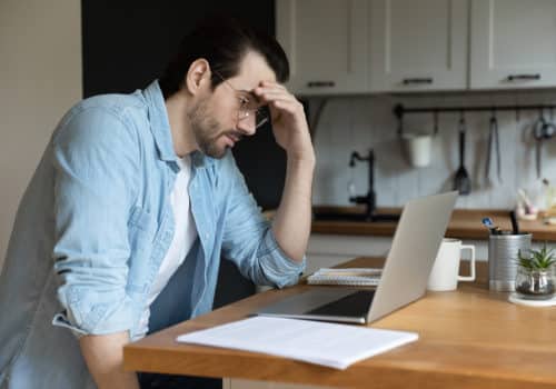 Homme qui réfléchit à souscrire une assurance solde restant dû