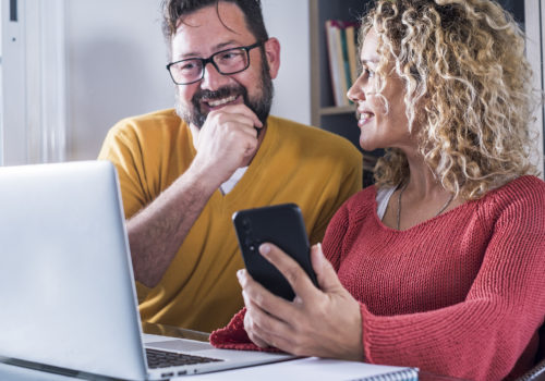 Heureux couple qui regarde pour faire un prêt pour rénover leur maison